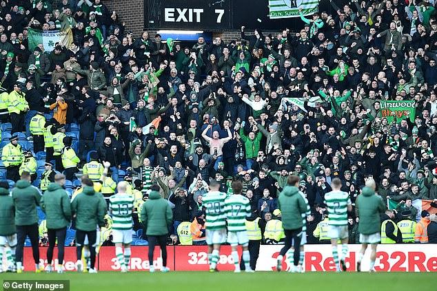 The Celtic players celebrate with their supporters at the final whistle after gaining a draw