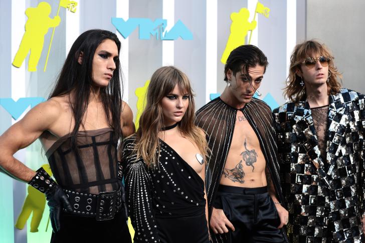 all four members of maneskin pose on the mtv vmas arrivals carpet wearing black and silver costumes