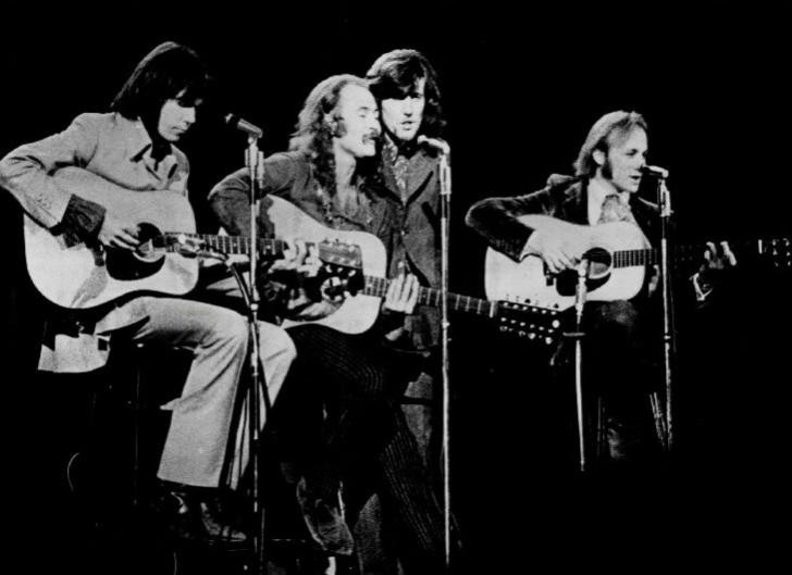 Black and white image of four musicians on stage.