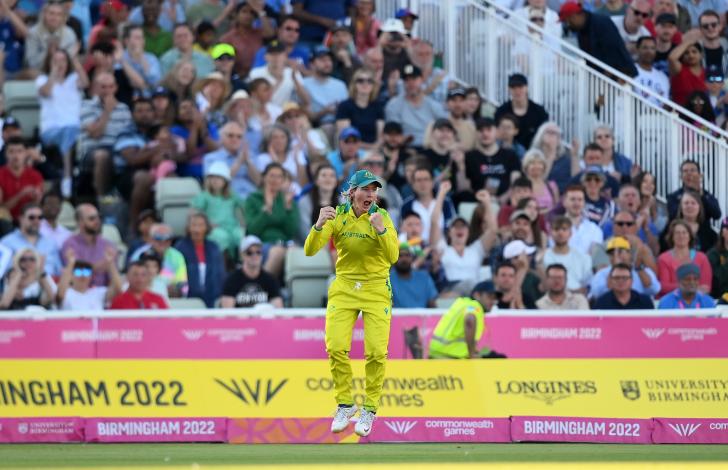 Australia fielder Beth Mooney shouts and pumps her fists after taking a catch in the Commonwealth Games cricket gold medal match